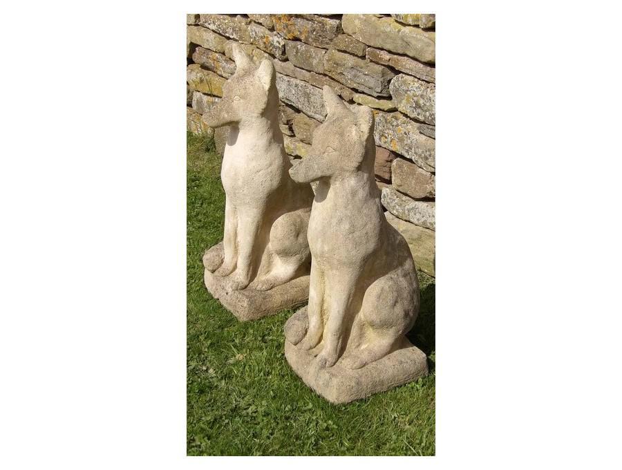 A pair of weathered stone foxes