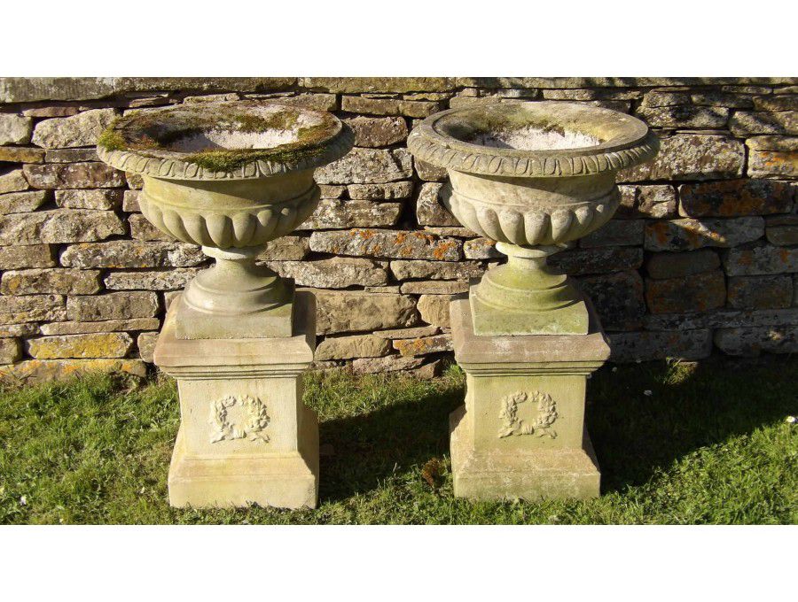 A pair of weathered Haddonstone urns